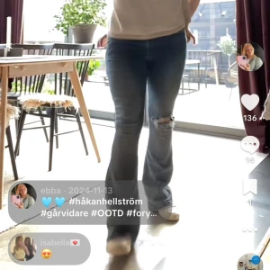 Blå low flare jeans från BikBok - Säljer ett par blå low flare jeans från BikBok med slitningar på ena knät och lätt tvättade detaljer. Modellen har låg midja och utsvängda ben, perfekt för dig som gillar en retro vibe. Klassisk femficksdesign och mjukt denimtyg.