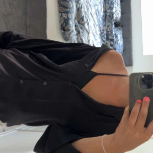 Svart oversized skjorta med knappar - Svart skjorta med avslappnad oversized passform och knäppning framtill. Långärmad och tillverkad i ett lätt material som kan användas över ett enkelt linne. Kontakta mig vid funderingar eller intresse!!😁