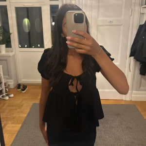 Svart blus med puffärm och knyt - Säljer min svarta pufftröja från Gina! Använd mycket men inget som syns🌸