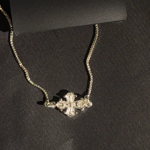 Silver plated korsarmband från Pilgrim - Snyggt oöppnad armband från Pilgrim i silverfärg med ett detaljerat kors som hänge. Kedjan är justerbar och tillverkad av minst 75% återvunnet material. Perfekt accessoar för dig som gillar stilrena smycken med en twist. ORIGINAL PRIS 349