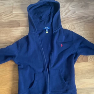 Mörkblå zip hoodie Ralph lauren storlek 14-16 years - Mörkblå polo Ralph lauren zip hoodie storlek 14-16 years, säljer den då den inte passar längre. Storleken är xs och den e i väldigt bra skick.