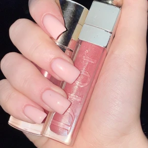 Dior glans - Säljer ett lyxigt rosa läppglans från Dior med silvrig kork och transparent hylsa. Glanset har en skimrande finish som ger läpparna en snygg glans och en hint av rosa färg. Perfekt för dig som vill ha en fräsch och glowy look.