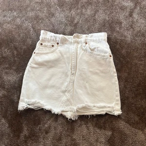 Vit jeanskjol från Zara med fransig kant - Säljer en vit jeanskjol från Zara i kort modell. Kjolen har fransig rå kant nertill, klassiska fickor fram och bak samt bälteshällor. Perfekt för dig som gillar en avslappnad och trendig stil. Superenkel att matcha med allt!