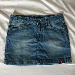 Blå jeanskjol  - Sjukt Snygg blå jeanskjol från edc med klassisk femficksdesign, bälteshällor och dekorativa bakfickor med broderad detalj. Kjolen har en kort modell och slitna partier för en cool look. Om midjemått önskas fixar jag så fort jag kan❤️