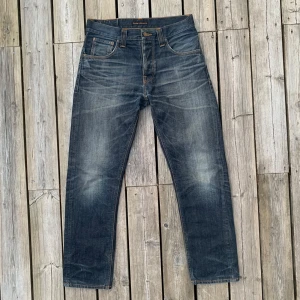 Sjuka Nudie jeans med Fades - Säljer dessa feta nudie jeans i den äldre modellen ”Steady Eddie” (inte den nuvarande modellen utan den första som kom ut✌️Rak modell med avsmalnande ben. Inköpt som dry denim och har fått naturliga slitningar med användning, unikare par får du inte‼️. Midja: 41 cm, Ytterbenslängd 102,5 cm. Väldigt fint skick för åldern men har tre minimala slitningar på låren (ett lagat). Nudie erbjuder som alltid gratis lagningar. Sällsynta kvalitetsjeans🌟