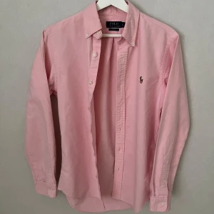 Rosa Ralph Lauren Skjorta - Strl S, Slim Fit - Hej säljer nu min fina Ralph Lauren skjorta i storlek S och den sjukt populära modellen Slim Fit. Den är i nyskick och kommer vara otroligt snygg på sommaren. Nypris cirka 1600kr! Vid frågor eller fundering tveka inte på att höra av dig! 🌊🍾