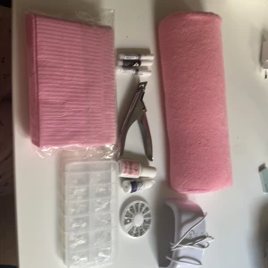 Nagelkit med rosa tillbehör - Komplett nagelkit med rosa armstöd, nagelservetter, nageltippar i plast, nagellim, nageldekorationer, nagelklippare, UV-lampa och flera små flaskor. Perfekt för att fixa snygga naglar hemma med både dekoration och verktyg. Tipparna är i formen almond!🌸