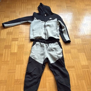 Nike tech fleece zip hoodie svart/grå  - Nike tech hoodie med dragkedja i svart och grått. Matchande byxor finns också för hel tracksuit. Äkta från Nike. Inte använd så mycket. 449kr för bara hoodien, 399kr för bara byxorna.