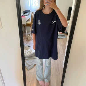 Mörkblå Puma Gothia Cup t-shirt L - Oversized mörkblå t-shirt från Puma med Gothia Cup-tryck och texten COACH på ärmen. Klassisk rund hals och korta ärmar. Skön bomullskvalitet och sportig vibe, perfekt för dig som gillar streetwear eller fotboll. Pris går att diskuteras