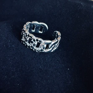 Fin handgjord flätad tåring i rostfritt stål! - Fin justerbar handgjord flätad tåring i rostfritt stål med svarta stenar. Köpt på vikingamarknad i Skåne för ca 20 år sen och legat oanvänd i tygpåse så i nyskick.