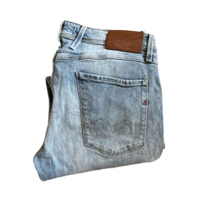 Replay anbass jeans  - Säljer ett par ljusblå jeans från Replay med klassisk femficksdesign och raka ben. Jeansen har läderpatch med Replay-logga bak i midjan och diskreta slitningar för en avslappnad look. Perfekta för dig som gillar en enkel och stilren denimstil. Jag skickar ej bild när jag bär plaggen och jag vet ej vilken längd och vikt de passar då jag inte prövar kläderna jag säljer 😃
