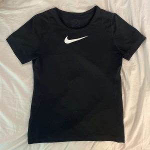 Svart Nike t-shirt - Svart tränings T-shirt ifrån Nike med klassisk vit logga. Skönt material och är i jättebra skick, perfekt för t.ex gym, tennis eller löpning 💕