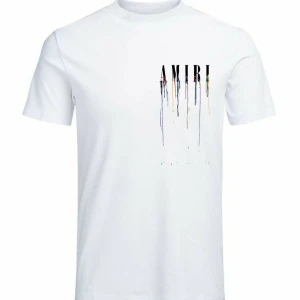 Vit AMIRI t-shirt med färgstänk - Vit t-shirt från AMIRI med tryckt logga och coola färgstänk som rinner ner över både fram- och baksidan. Klassisk passform med rund hals och korta ärmar. Perfekt statement-plagg för dig som gillar streetstyle och unika detaljer.