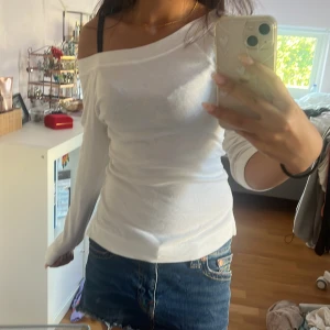 Vit offshoulder topp från Mango - Säljer en vit trekvartsärmat offshoulder topp från Mango Basics. Toppen är i mjuk bomull och har en snygg, enkel design med bred halsringning som sitter snyggt över axlarna och trekvart ärmar. Perfekt att styla med jeans eller kjol för en clean look.