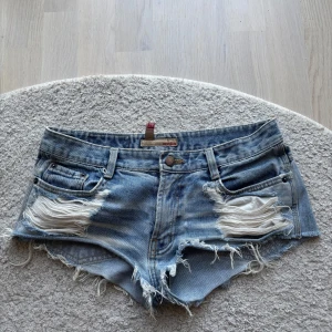 Ljusblå jeansshorts med slitningar - Säljer dessa sjukt snygga ljusblåa jeansshorts med litna detaljer både fram och bak, tyvärr blivit lite för små för mig