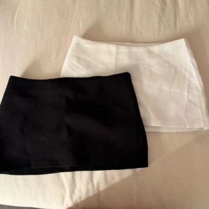 Svart och vit kortkjol  - Två minikjolar i svart och vitt, båda i enkel basic design. Dom båda har en diskret dragkedja på sidan. Och dom båda har som små shorts under som ni kan se på en bild. dom är inte jätte streschiga och dom här är M men är mer s/m. 