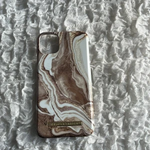 Mobilskal i marmorlook från iDeal of Sweden till Iphone 11 - Säljer ett snyggt mobilskal från iDeal of Sweden med marmorliknande mönster i bruna och vita toner. Funkar även med plånboksskalet till Iphone 11