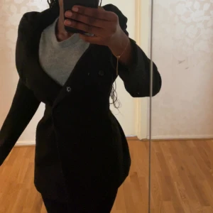 Svart kappa  - Säljer en svart kappa med bälte i midjan och dubbelknäppning. Llångärmad modell som passar perfekt till kyligare och regnigare dagar. Snygg design som funkar till många outfits🤩Säljer pga att jag inte använder den mer. Knappt använd och är som ny💓
