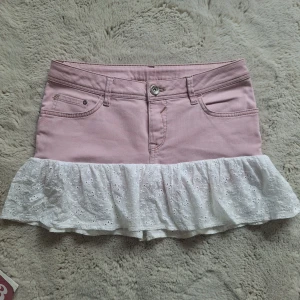 Rosa jeanskjol med vit volang - Supersöt rosa jeanskjol med vit broderad volangkant. Jag har sytt den själv för att sälja, kommer lägga upp fler som denna snart. Tryck ej på köp nu, vill se vad folk är redo att betala🩷