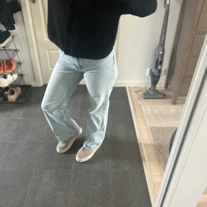 Ljusblå raka jeans - Säljer ett par ljusblå jeans med rak, vida passform och normal midja. Klassisk femficksmodell med knapp och dragkedja framtill. Perfekta till vardags för en avslappnad stil.