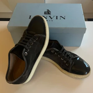 Gråa sneakers från Lanvin med lackad tå - Säljer ett par riktigt fräscha Elephant Grey Lanvins med snygg lackad tå. Sitter oftast 1 storlek stort. Märket syns på kartongen och skorna har en exklusiv känsla. Vid minsta lilla fundering kontakta mig! Priset är ej hugget i sten😊