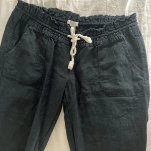 Svarta linnebyxor från Roxy - Svarta linnebyxor från Roxy med breda ben och vit snörning i midjan. Jättefina och perfekta till sommaren, använda en gång då de tyvärr är för korta på mig. Har sytt ner byxorna längst ner för att göra dom lite längre men det är inget som man tänker på❤️ nypris 600 kr, lite små i storlek så passar både S och M skulle jag säga. ❤️