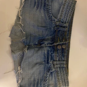 Ljusblå jeanskjol med fransar från Miss Milla - Säljer ett par ljusblå jeanskjol från Miss Milla med råa franskantade benslut och dubbla bälteshällor. Klassisk femficksmodell🥰🥰 super snygga vintage sommar kjol❤️
