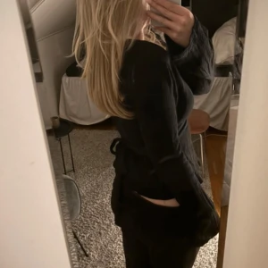 Festtopp  - Säljer en svart långärmad topp. Finns snören där bak till för att knyta rosett. Fin topp med fin rosett där baktill!