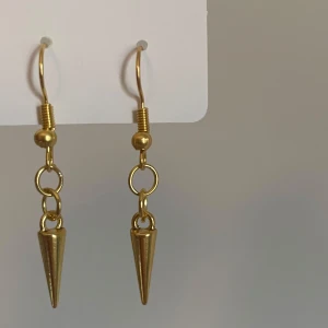 Handgjorda guld örhängen med nitar  - Snygga handgjorda örhängen i guld med konformade hängen. Perfekta för att ge din look en cool och trendig touch. Passar dig som gillar unika accessoarer och vill sticka ut lite extra.
