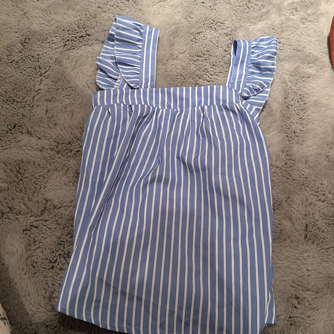 Blå- och vitrandig linne med volangdetaljer