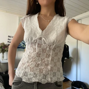 Söt spetsblus från More - Söt vit blus i spets med v-ringning och knyt framtill. Blusen har korta ärmar och är tillverkad i ett tunt, blommigt spetsmaterial ❤️ Har extra tyg vid börsten så den blir inte genomskinlig 🫶