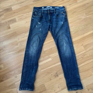 Replay Anbass jeans age 05 - Säljer ett par blå Replay Anbass jeans (age 05)  med slitningar samt att de har en snygg o unik  tvätt. I princip nyskick då de tagits väl hand om. Hör av er om ni har minsta fundering!