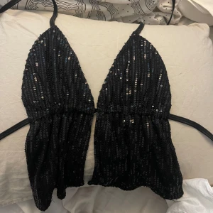 Svart paljettopp från Motel - Säljer en svart glittrig paljettopp från Motel,  Toppen har knyt i midjan. Fler bilder kan skickas❤️