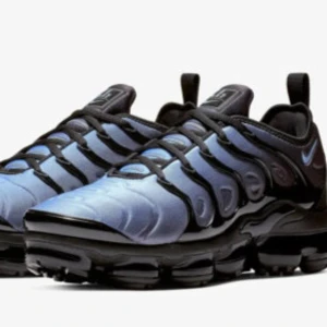 Nike Air Vapormax Plus blå och svarta sneakers - Nike Air Vapormax Plus sneakers i blått och svart med en futuristisk design. Ovandelen har en blå och med svarta detaljer. Jag har inte använd dom länge 