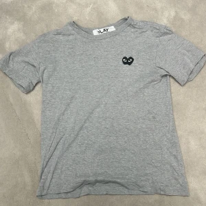 CDG T-shirt - Galet fet grå CDG tisha!🔥Synligt använd men fof bra skick och därmed det låga priset. Storlek S och passar mindre, perfa för er lil jitz🔥Svarar alltid DM, pris såklart diskuterbart. Ny pris 1100kr från Paul and Friends på NK