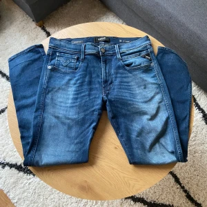 Klassisk mörkblåa Replay jeans - Hej👋 Säljer ett par klassiska mörkblåa jeans från Replay i Anbass modell med raka ben och snygga slitningar. Byxorna har också hyperflex material!🧶  Byxorna har fem fickor, dragkedja och knapp framtill samt Replay-logga på bakfickan. Perfekta för dig som gillar en tidlös och enkel jeanslook👖  Storleken är W32 L30📏  Priset kan diskuteras vid snabb affär!💸  Vid några frågor: Meddela📩