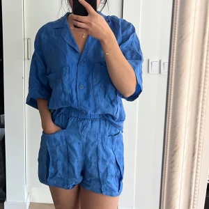 Blått set Zara - Set från Zara med shorts och kortärmad skjorta i härlig blå färg, materialet är i zaras benämning ”fillsens” eller vad det heter, väldigt svalt och mjukt material.  Båda delarna storlek XS och shortsen har resår i midjan så dom är väldigt elastiska. Delarna normala i storleken. 