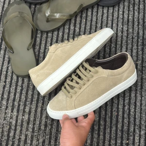 Massimo dutti mockasneakers med vit sula - Stilrena sneakers i beige mocka med vit platt sula och snörning. Insidan är fodrad med mörkbrunt skinn för extra komfort. Perfekta för dig som gillar en clean och klassisk look. Tillverkade i Portugal.