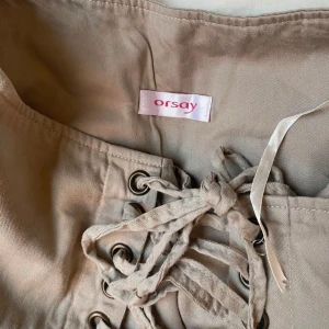 Beige kjol/topp med snörning från Orsay - Beige kjol från Orsay som jag använt som topp. Skulle säga att de är XS/XXS. Så fina detaljer.