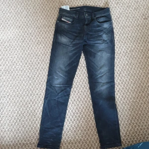 Mörkblå skinny jeans från Diesel W30 - Snygga mörkblå jeans från Diesel med klassisk femficksdesign och diskreta slitningar. Modellen är skinny fit med smala ben och normal midja. Jeansen har Diesel Industry-märke på fickan och patch bak. Perfekta till sneakers eller boots.