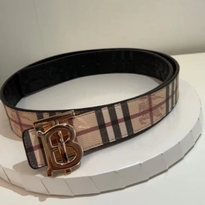 Burberry bälte  - En fet bälte från burberry. Det är ett vändigt bälte som du kan vända så du kan ha den svarta sidan och den beige sidan. Storlek: 120cm. 