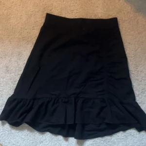 Svart kjol med volangkant🫶🏻 - Svart kjol med snygg volang längst ner🙌🏼 Kjolen har en enkel, rak passform och är lätt att matcha med olika toppar. Perfekt för sommaren🌸