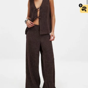 Bruna vida byxor i plisserat tyg - säljer dessa snygga slutsålda byxor från NA-KD. Helt nya med lapparna kvar! 