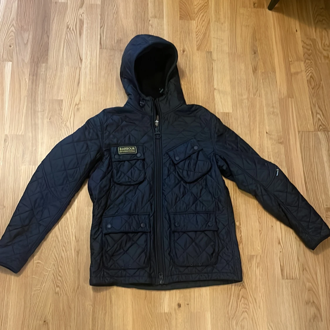 Svart quiltad jacka med huva från Barbour International - 1