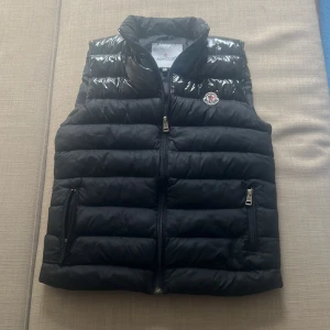 Moncler väst - Säljer en svart dunväst från Moncler i storlek 14y men funkar också som xs. Pris går att diskutera vid snabbt köp. Såklart äkta