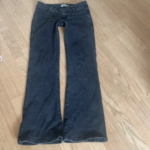 Svarta bootcut jeans med låg midja - Säljer ett par svarta jeans med bootcut-modell och låg midja. Jeansen har klassisk femficksdesign och stängs med två knappar. Aldrig använda så i nyskick. De är i storlek S och i full lenght så de är rätt långa