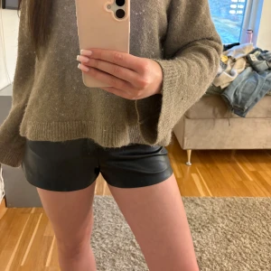 Svarta skinnshorts från ZARA - Snygga svarta shorts i skinnimitation från ZARA. De har en klassisk passform med fickor fram och stängs med dold dragkedja. Perfekta för en trendig look och enkla att matcha med olika toppar.