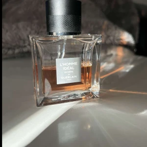 L'Homme Idéal Extrême Eau de Parfum - Exklusiv herrparfym från Guerlain, L'Homme Idéal Extrême. Flaskan är fyrkantig med transparent glas och svart lock. Doften har en varm, kryddig och mandelaktig karaktär med inslag av trä och tobak.