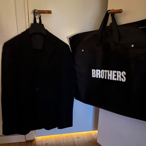 Svart kostym från Brothers - Säljer en klassisk svart kostym från Brothers i storlek 48. Kostymen har en kavaj med två knappar och klassiska slag samt matchande byxor. Materialet är 100% polyester vilket gör den lättskött och bekväm. Köpte den för 3 år sedan och nästan aldrig använt den. Tveka inte att fråga om ni undrar något, pris kan alltid diskuteras vid smidig affär! MVH