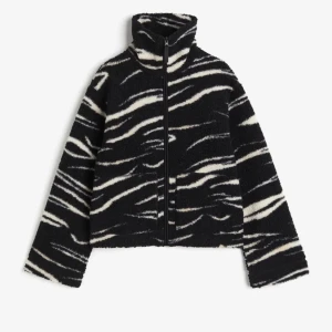 Svart och vit teddyjacka med zebramönster - Säljer min Teddy jacka i storlek S från H&M då den aldrig används längre. Den är i bra skick och har inga hål eller skador. 